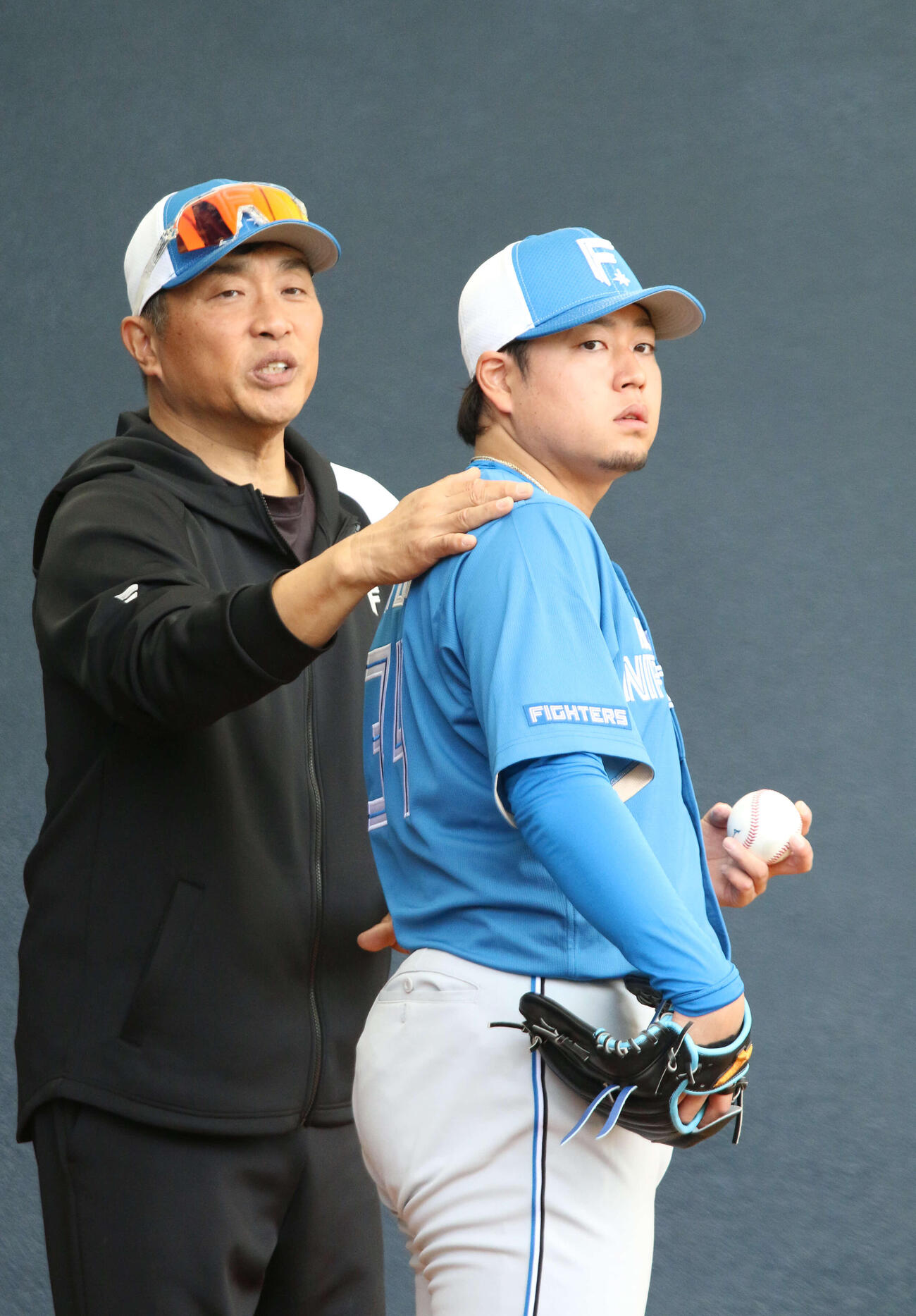 ブルペン入りした日本ハム堀（右）に指導する山本昌臨時コーチ（撮影・木下大輔）