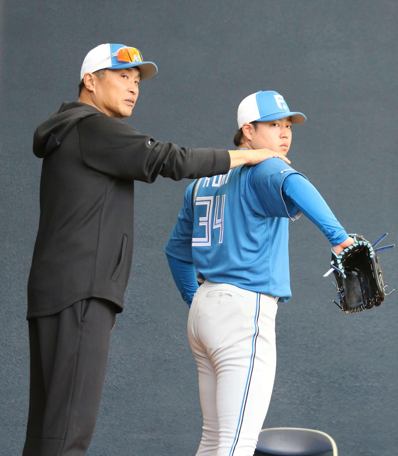 ブルペン入りした日本ハム堀（左）に指導する山本昌臨時コーチ（撮影・木下大輔）