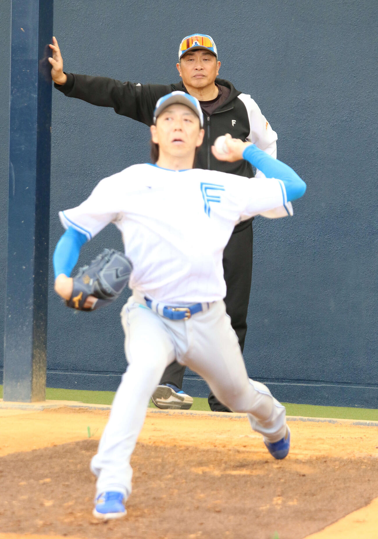 ブルペン入りした日本ハム宮西（手前）をチェックする山本昌臨時コーチ（撮影・木下大輔）