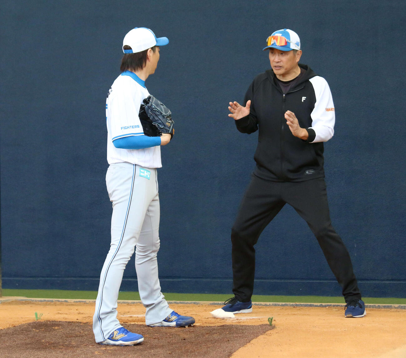 ブルペン入りした日本ハム宮西（左）に指導する山本昌臨時コーチ（撮影・木下大輔）