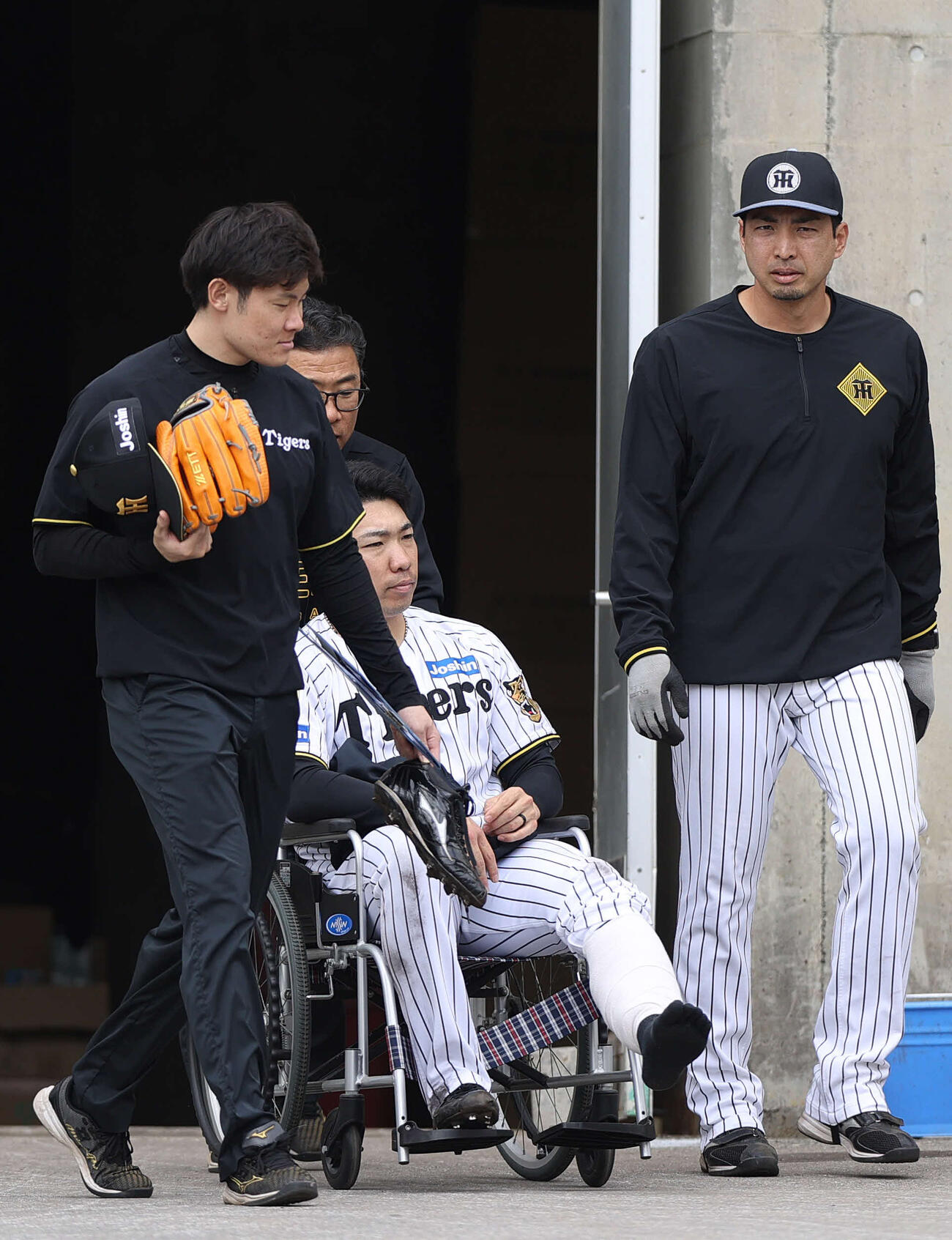 2月11日、紅白戦で足を負傷し車椅子で移動する阪神石井（撮影・上山淳一）