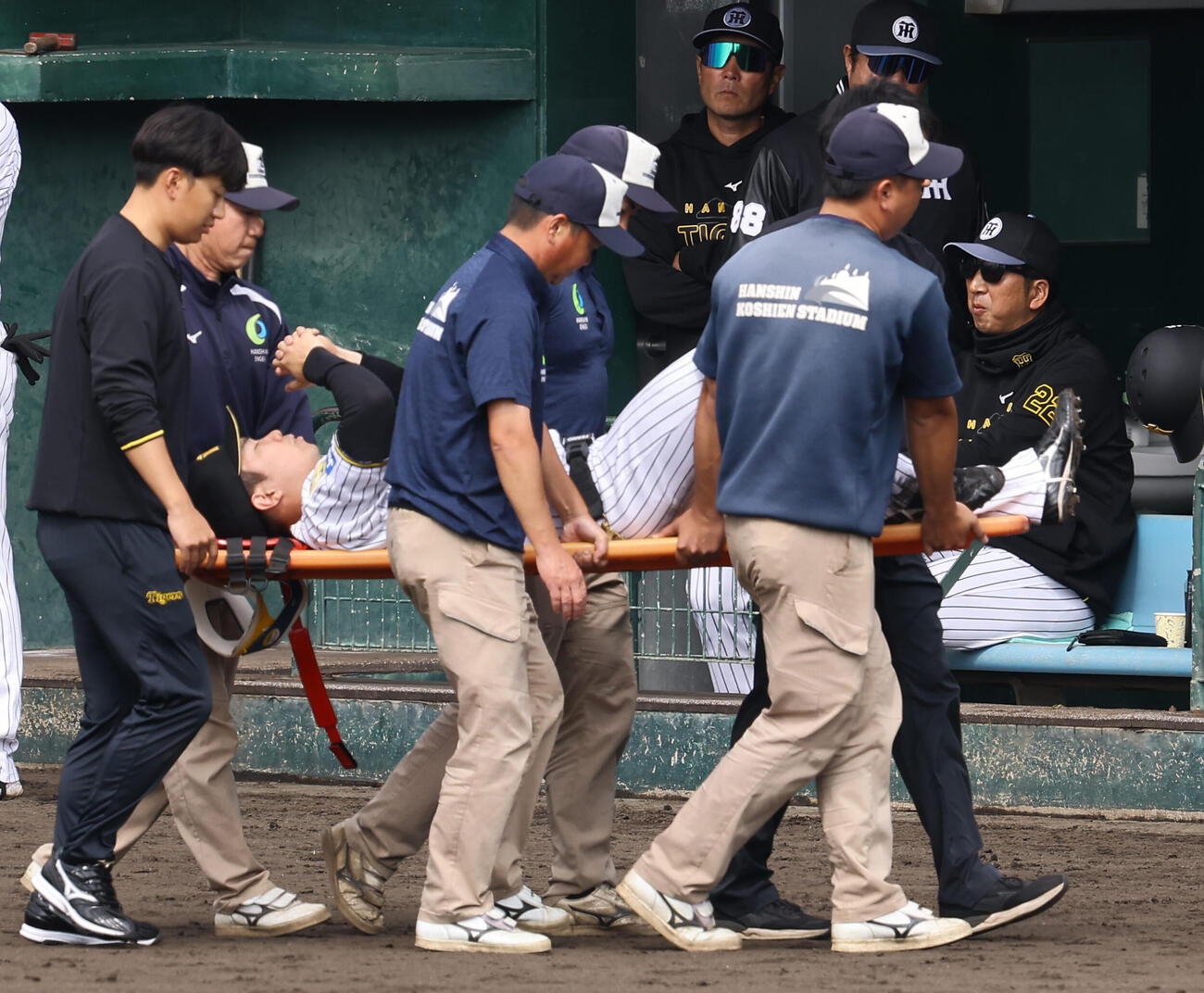 2月11日、紅白戦で足を負傷し、ストレッチャーで運ばれる石井。ベンチ右は藤川監督