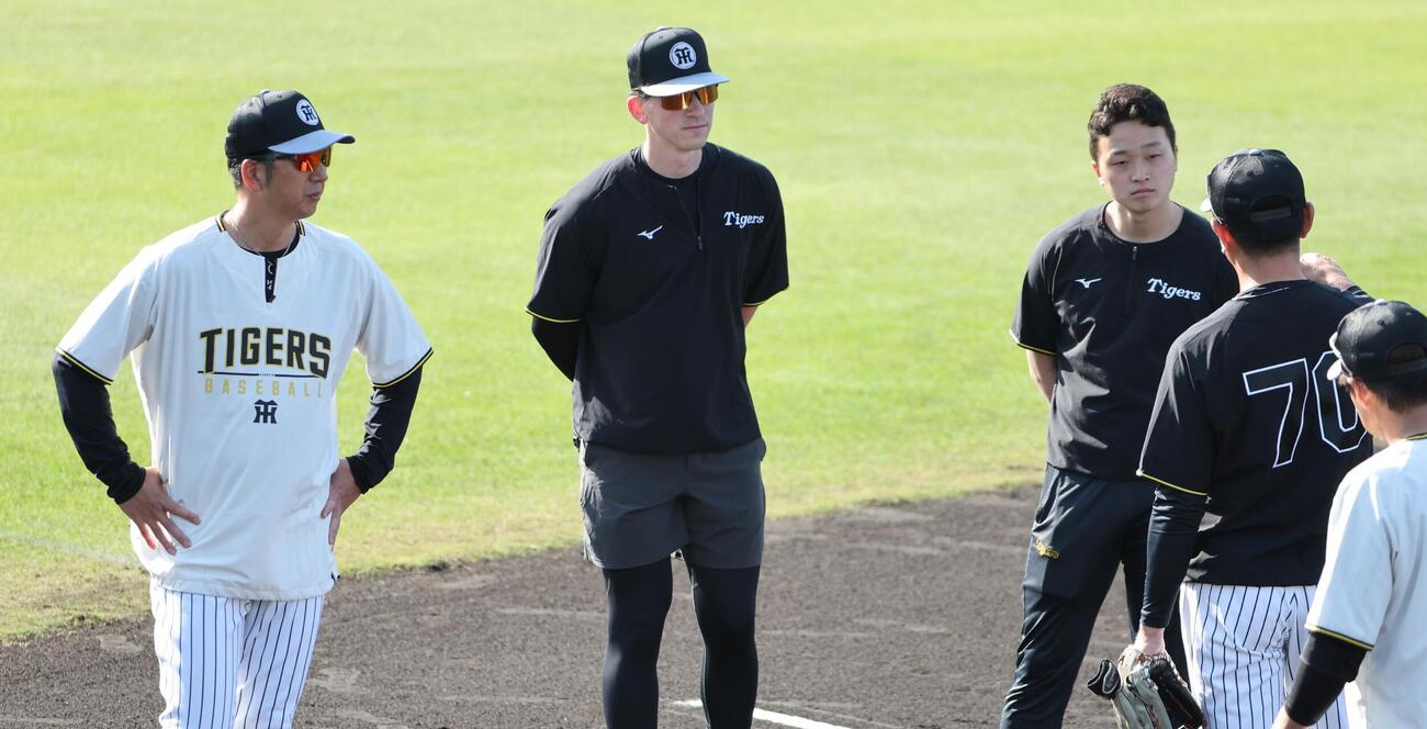 早出ノックを受けた阪神ディベイニーは藤川監督とともに田中コーチの話を聞く（撮影・西尾就之）