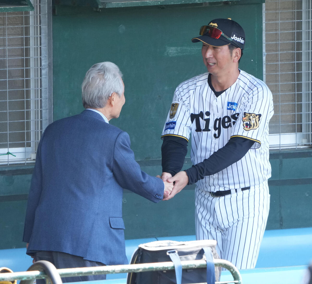 榊原コミッショナー（左）と握手を交わす藤川監督（撮影・森本幸一）