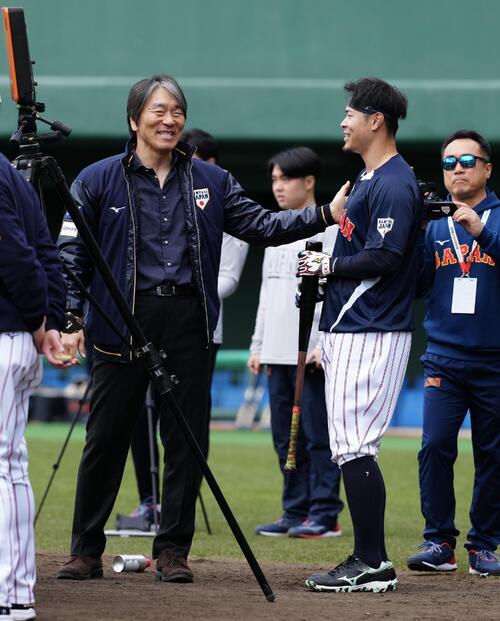 松井氏（左）に肩をたたかれ笑顔を見せる佐藤輝（撮影・垰建太）