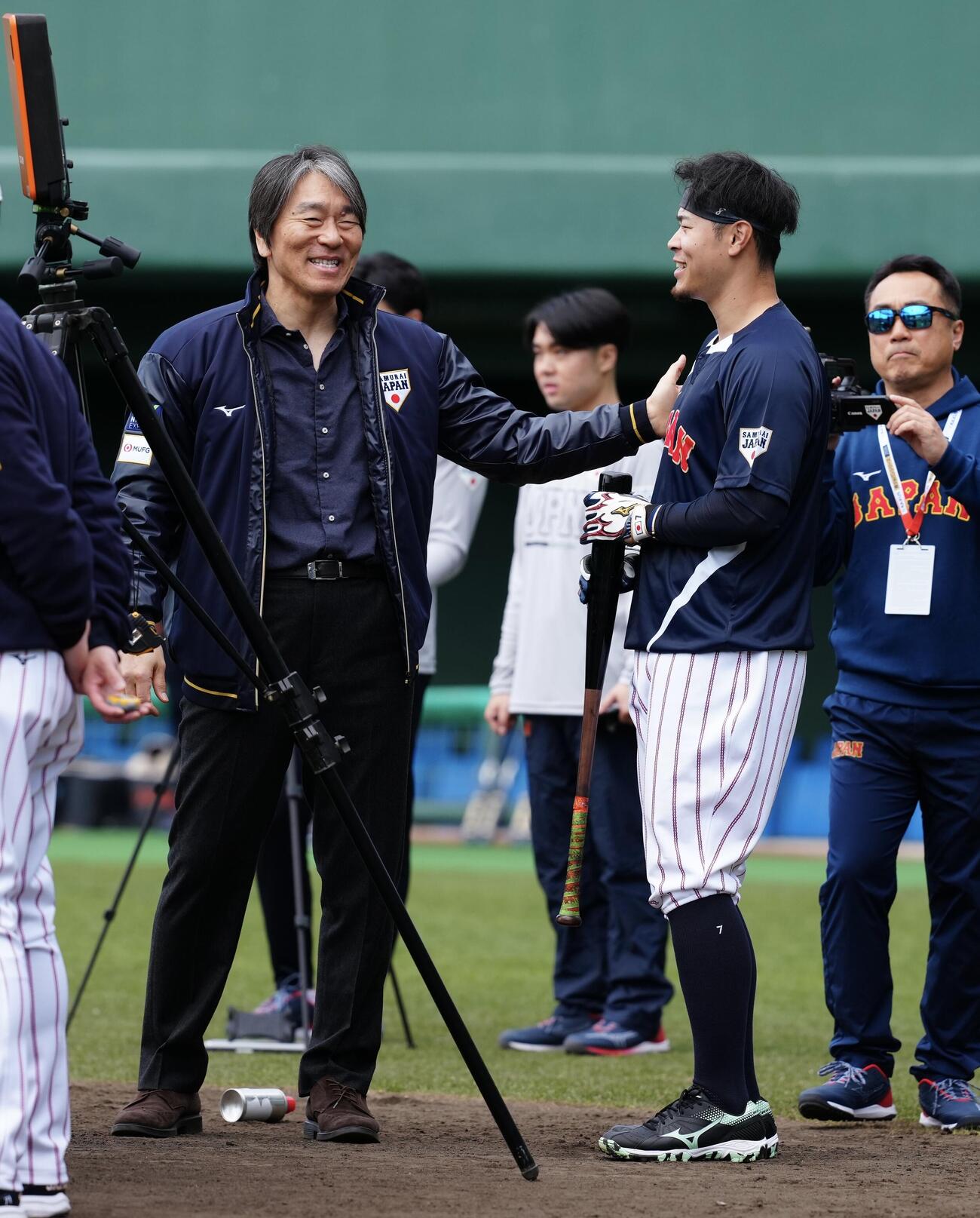 松井氏（左）に肩をたたかれ笑顔を見せる佐藤輝（撮影・垰建太）