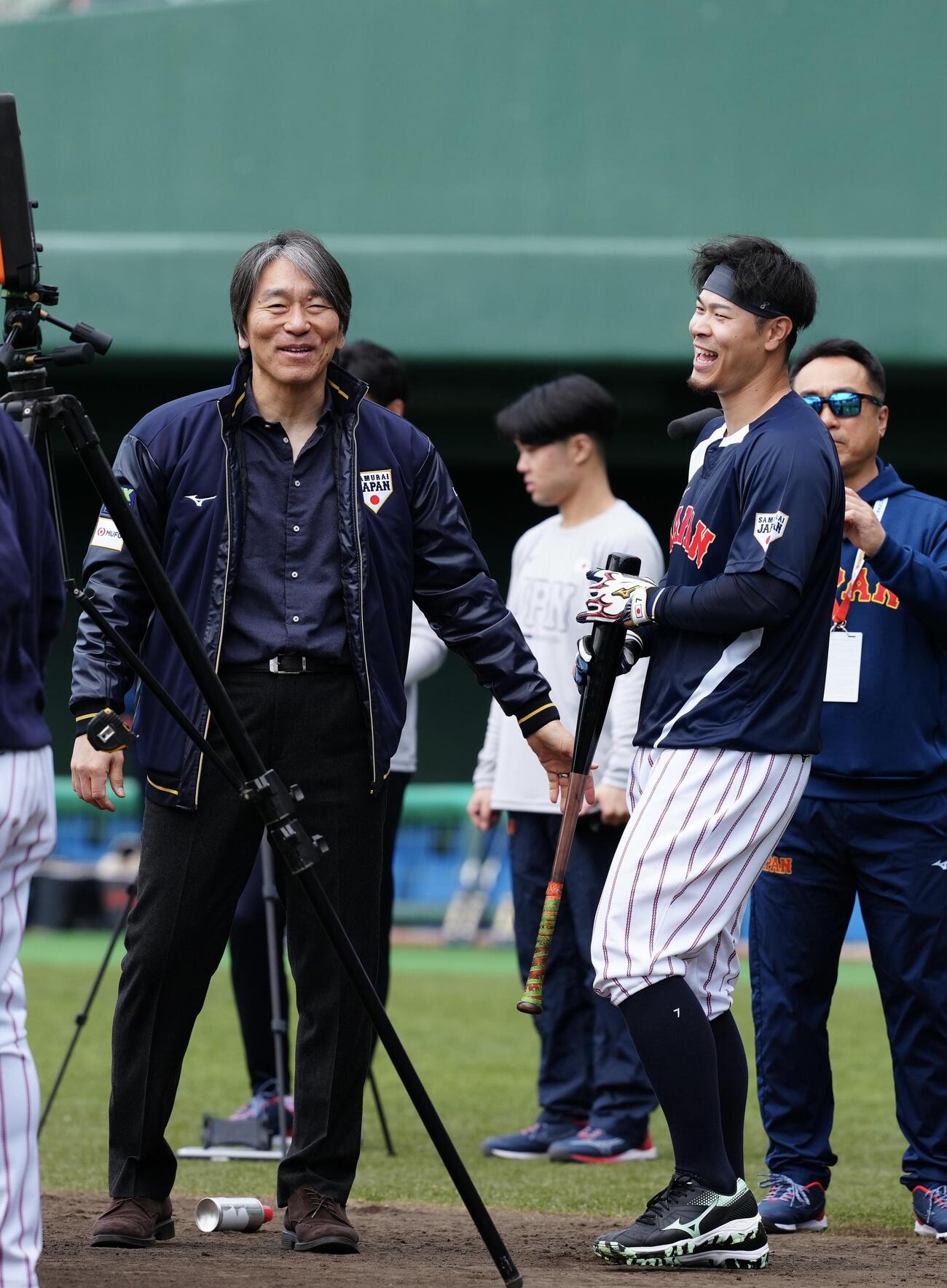 松井氏（左）に肩をたたかれ笑顔を見せる佐藤輝（撮影・垰建太）