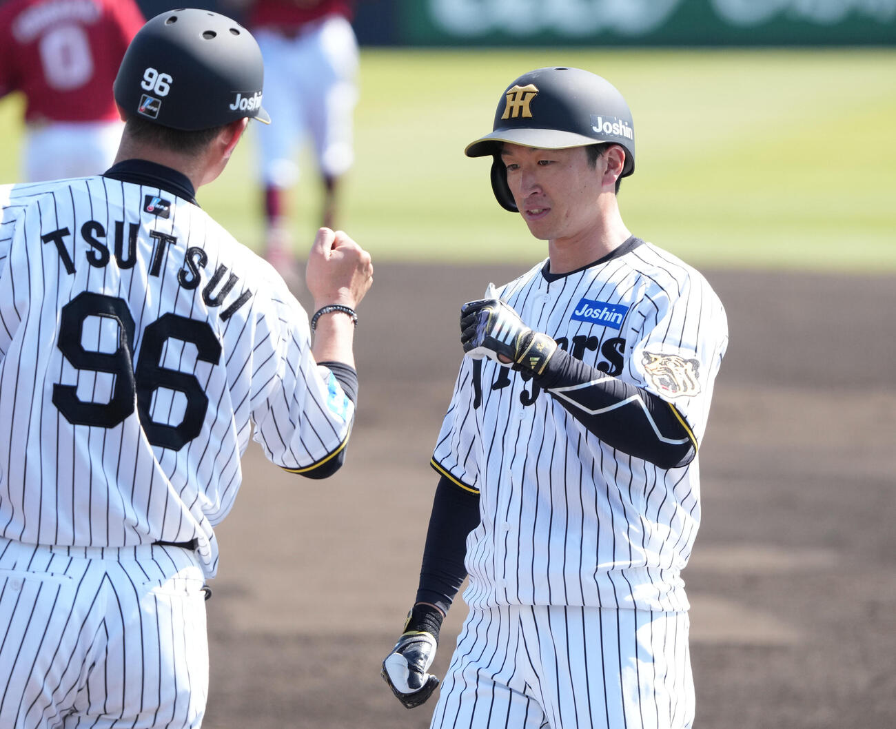 練習試合　阪神対楽天　4回裏阪神無死、近本（右）は左前打を放ちタッチを交わす（撮影・森本幸一）