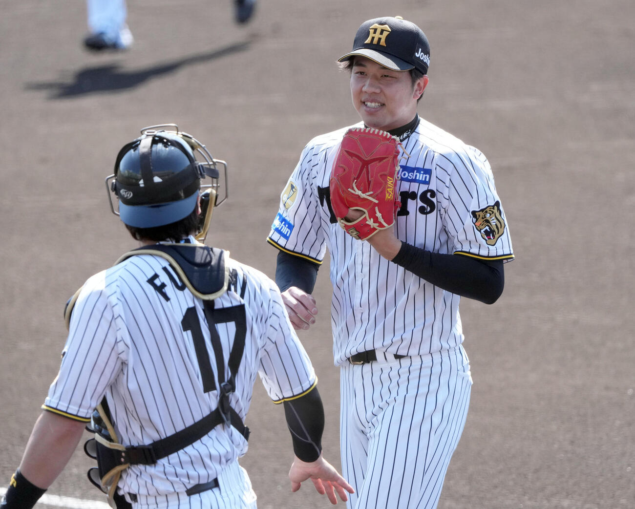 練習試合　阪神対楽天　1回表終了、伏見（左）と言葉を交わしベンチへ戻る阪神先発の才木（撮影・森本幸一）