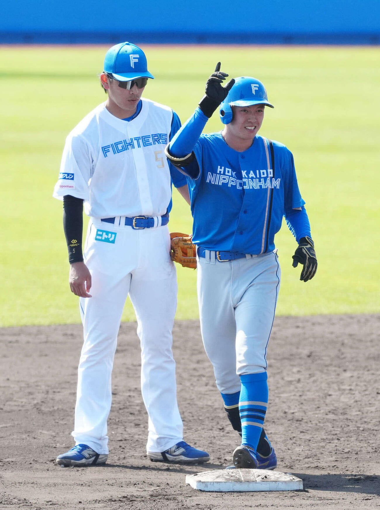 紅白戦の4回、二塁打を放ち、ベンチに向かって「DOMIれ！」ポーズを見せる日本ハム藤森（右）（撮影・江口和貴）