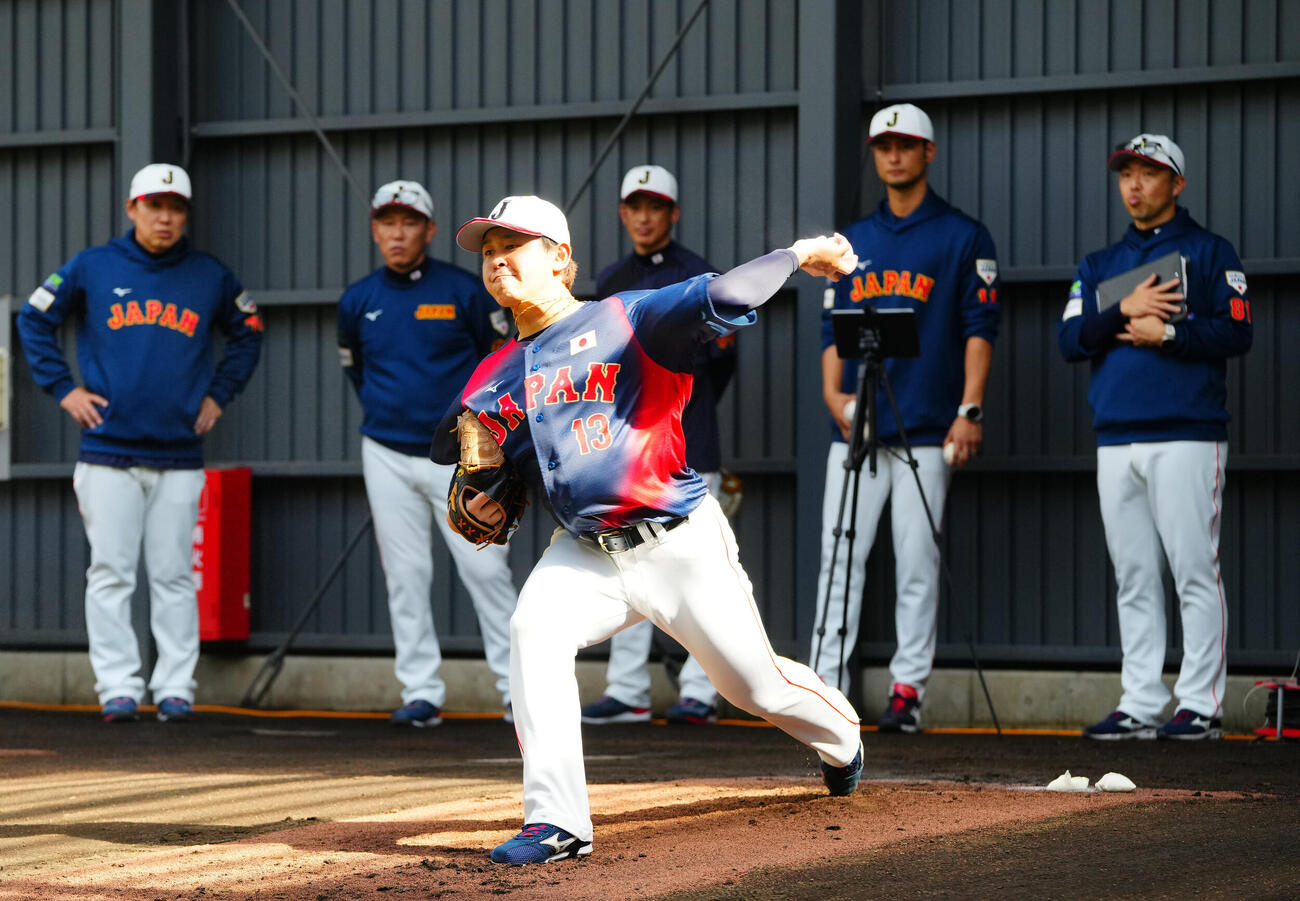 ブルペンで宮城（手前）は、後方左から村田バッテリーコーチ、井端監督、能見投手コーチ、アドバイザーのダルビッシュ、吉見投手コーチが見つめる前で投球する（撮影・垰建太）