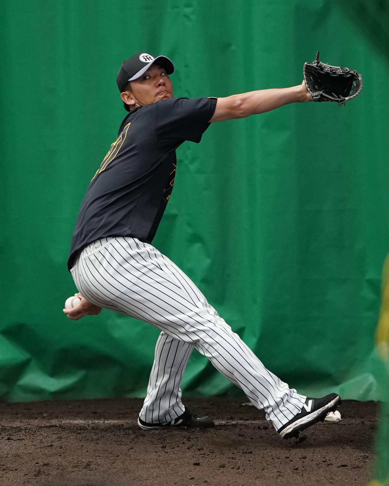 ブルペンで投球練習をする伊藤将（撮影・森本幸一）