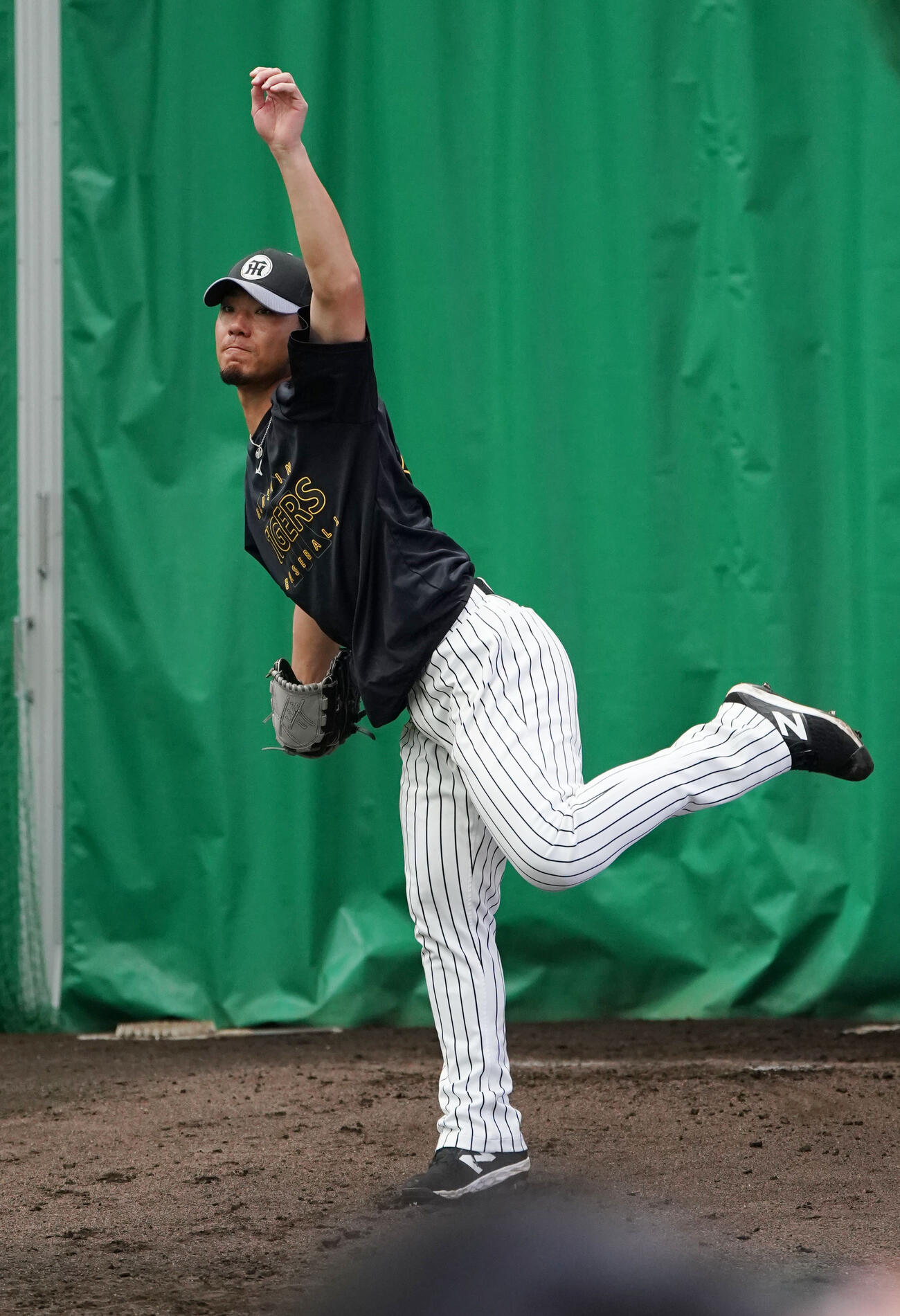 ブルペンで投球練習をする伊藤将（撮影・森本幸一）