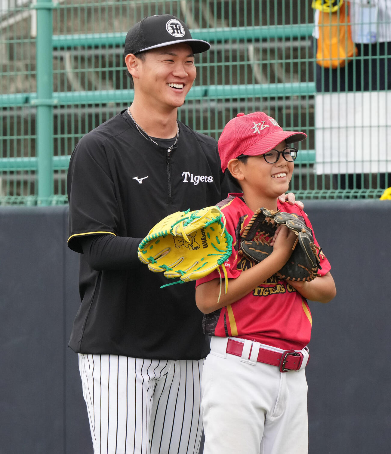 及川（左）は練習後に行われた野球教室で子どもたちにアドバイスをする（撮影・森本幸一）