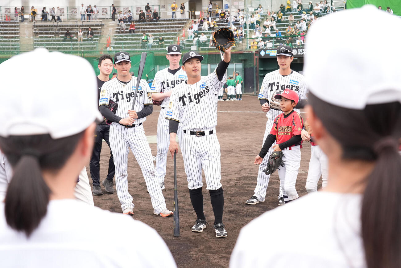 熊谷（中央）は練習後に行われた野球教室で子どもたちにアドバイスをする（撮影・森本幸一）