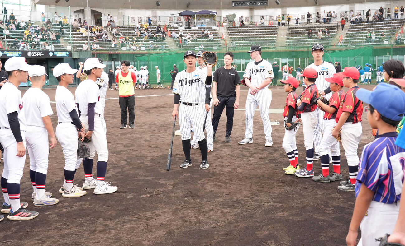 熊谷（中央）は練習後に行われた野球教室で子どもたちにアドバイスをする（撮影・森本幸一）
