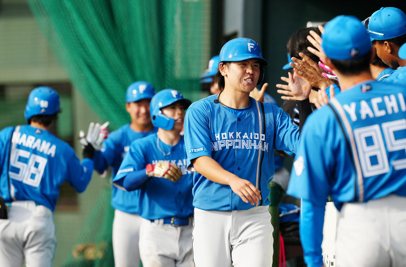 楽天対日本ハム　9回表日本ハム1死満塁、矢沢の3点適時二塁打で生還しタッチを交わす清水優（中央）ら（撮影・江口和貴）