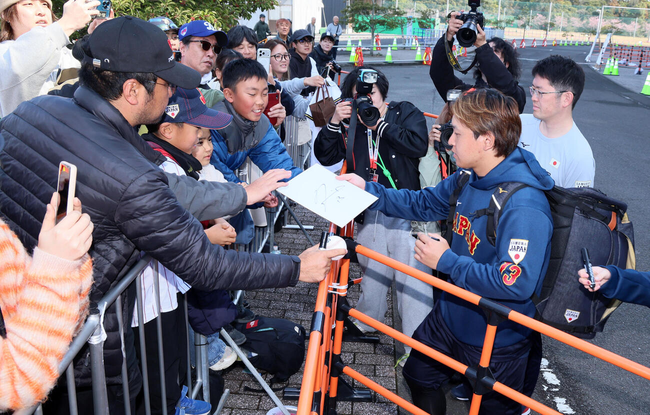 休日返上で球場を訪れ練習した侍ジャパン宮城は待っていたファンにサインする（撮影・加藤哉）