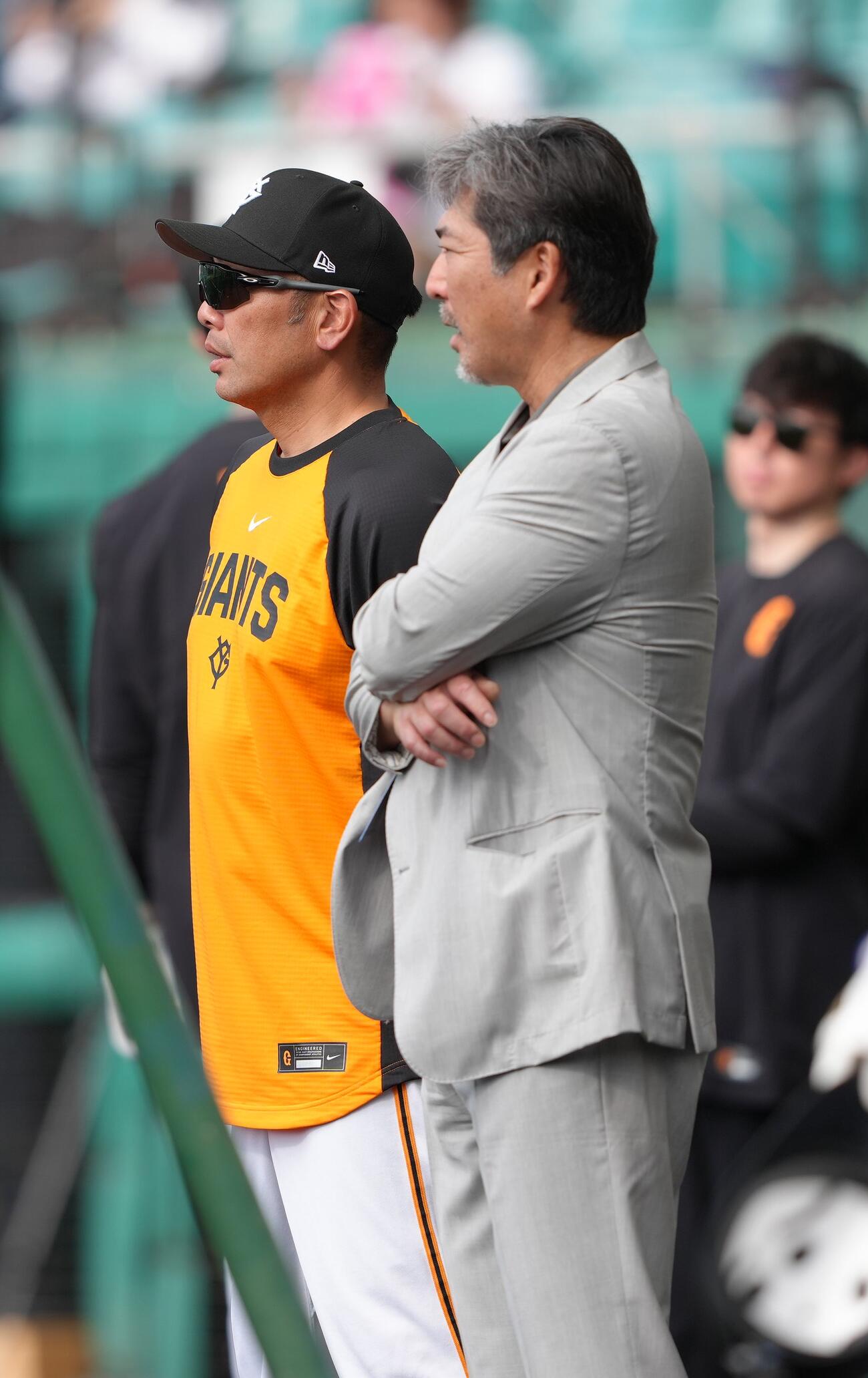 練習中、会話を交わす巨人阿部監督（左）と小笠原氏（撮影・足立雅史）