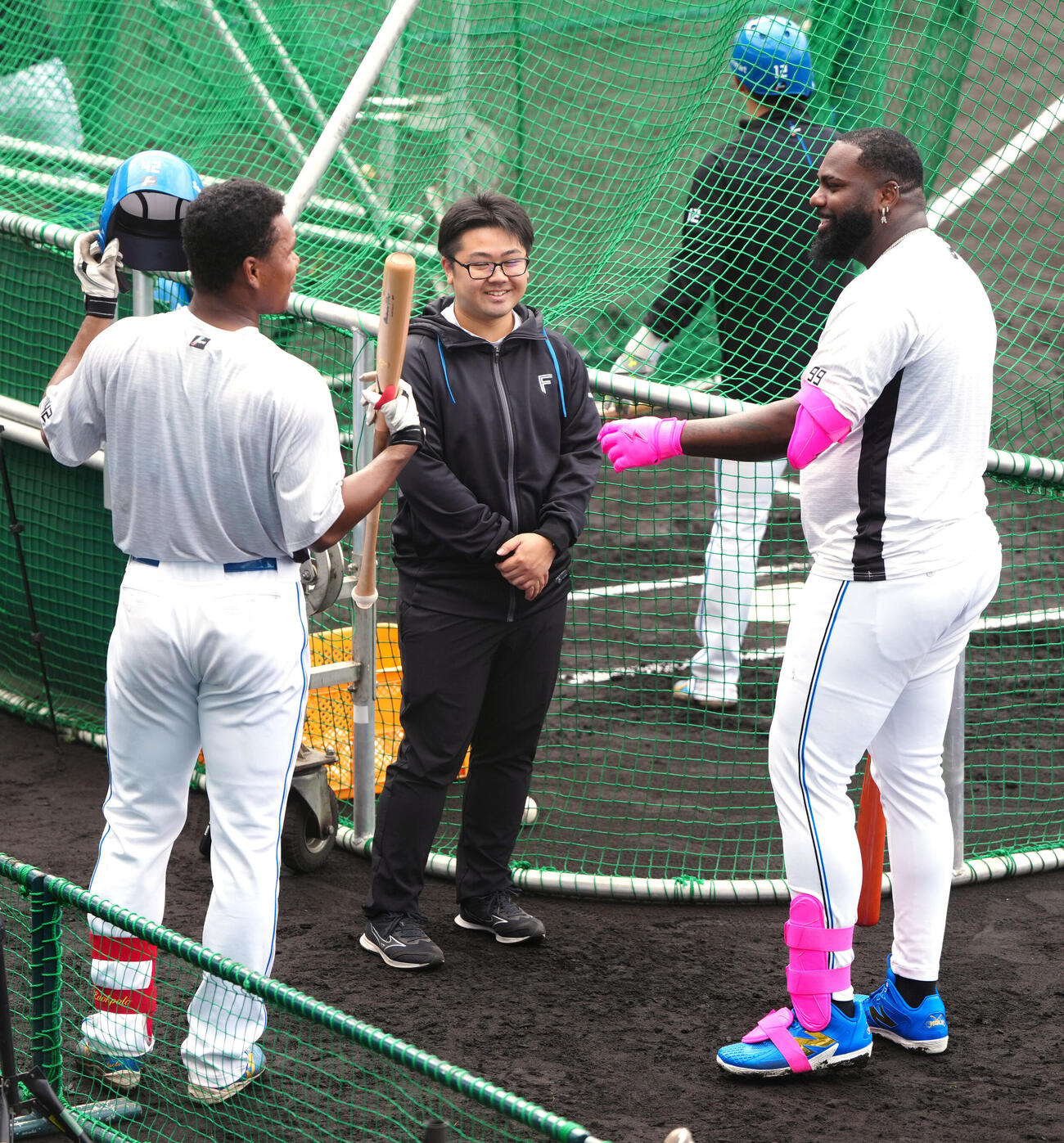 打撃練習中、新人の日本ハム・エドポロ（左）と言葉を交わすレイエス。中央は古川通訳（撮影・江口和貴）