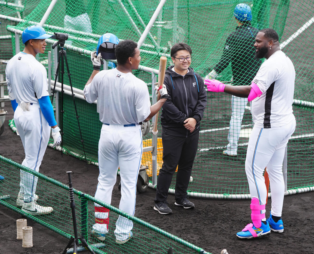 打撃練習中、新人の日本ハム・エドポロ（中央左）と言葉を交わすレイエス（右）。左は万波、中央右は古川通訳（撮影・江口和貴）