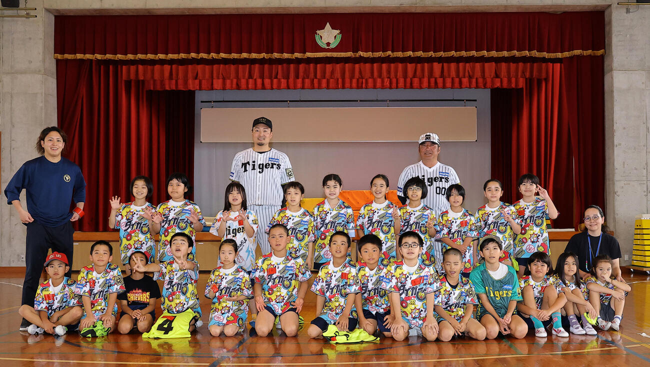 ゲストティーチャーで訪れた松田小学校で児童らと記念撮影をする阪神秋山BA（中央左）とOBの亀山氏（撮影・上田博志）