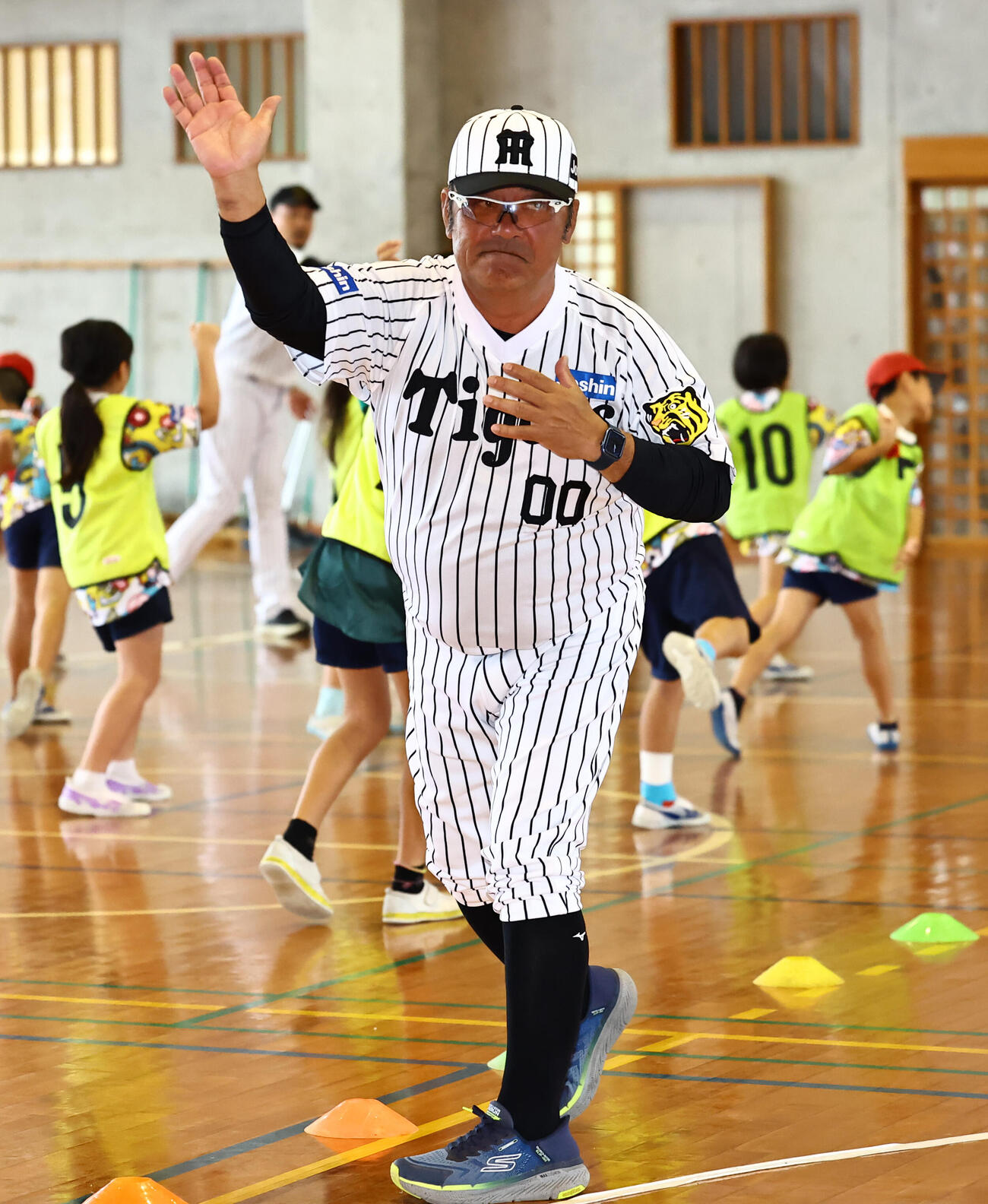 ゲストティーチャーで松田小学校を訪れたOBの亀山氏は児童に投げ方を教える（撮影・上田博志）
