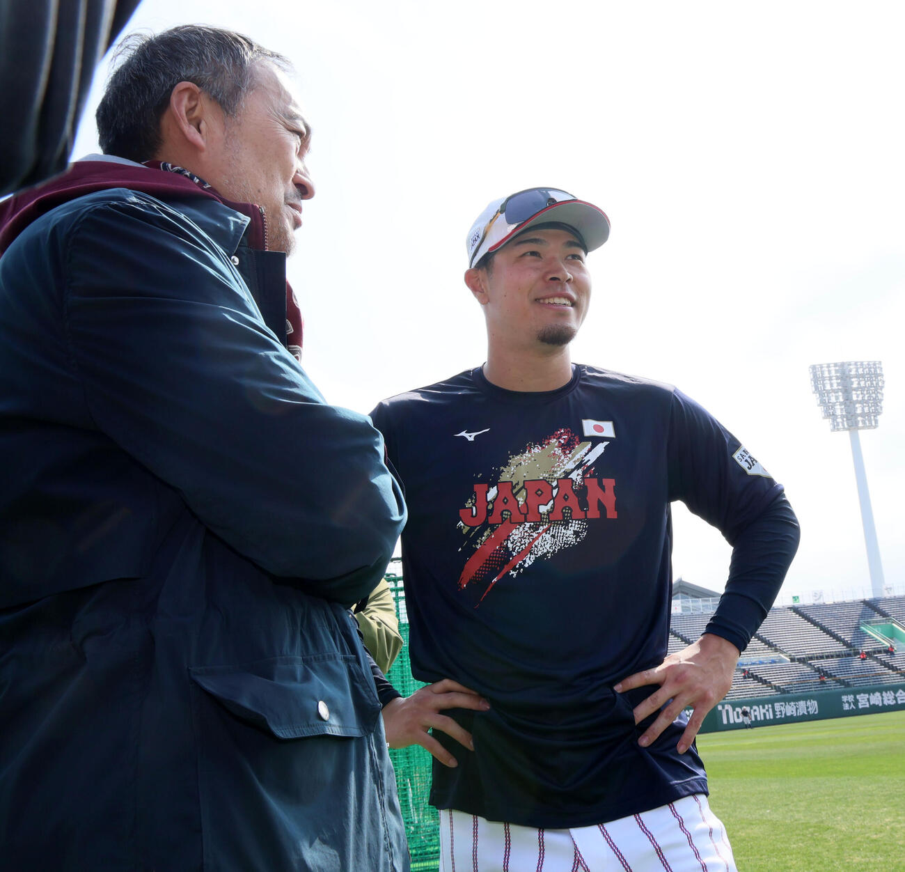 球場を訪れた俳優の渡辺謙（左）と話す侍ジャパン佐藤（撮影・加藤哉）