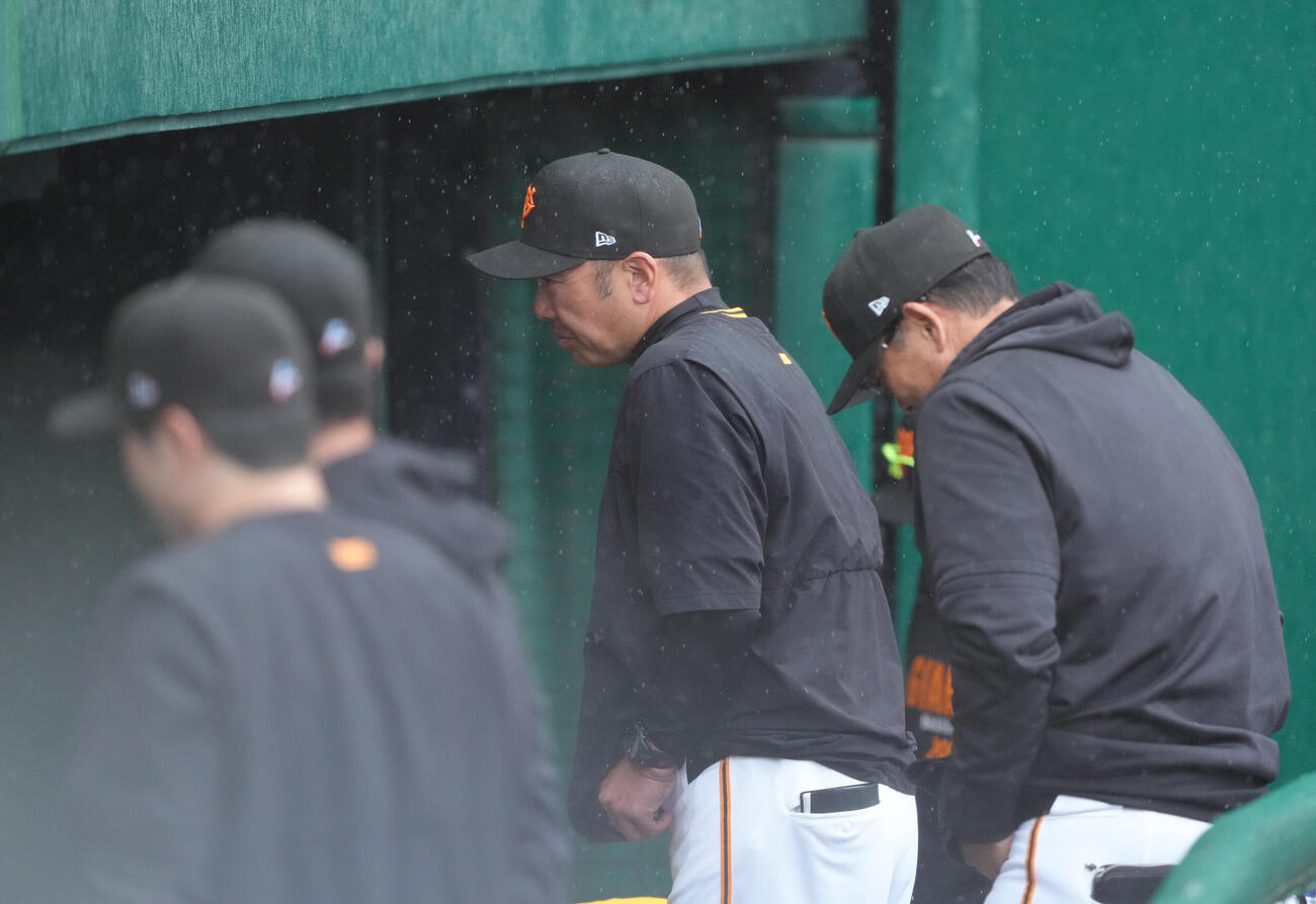 練習試合　巨人対ロッテ　雨が強まり試合が中断し、ベンチ裏へと下がる巨人阿部監督（中央）（撮影・足立雅史）
