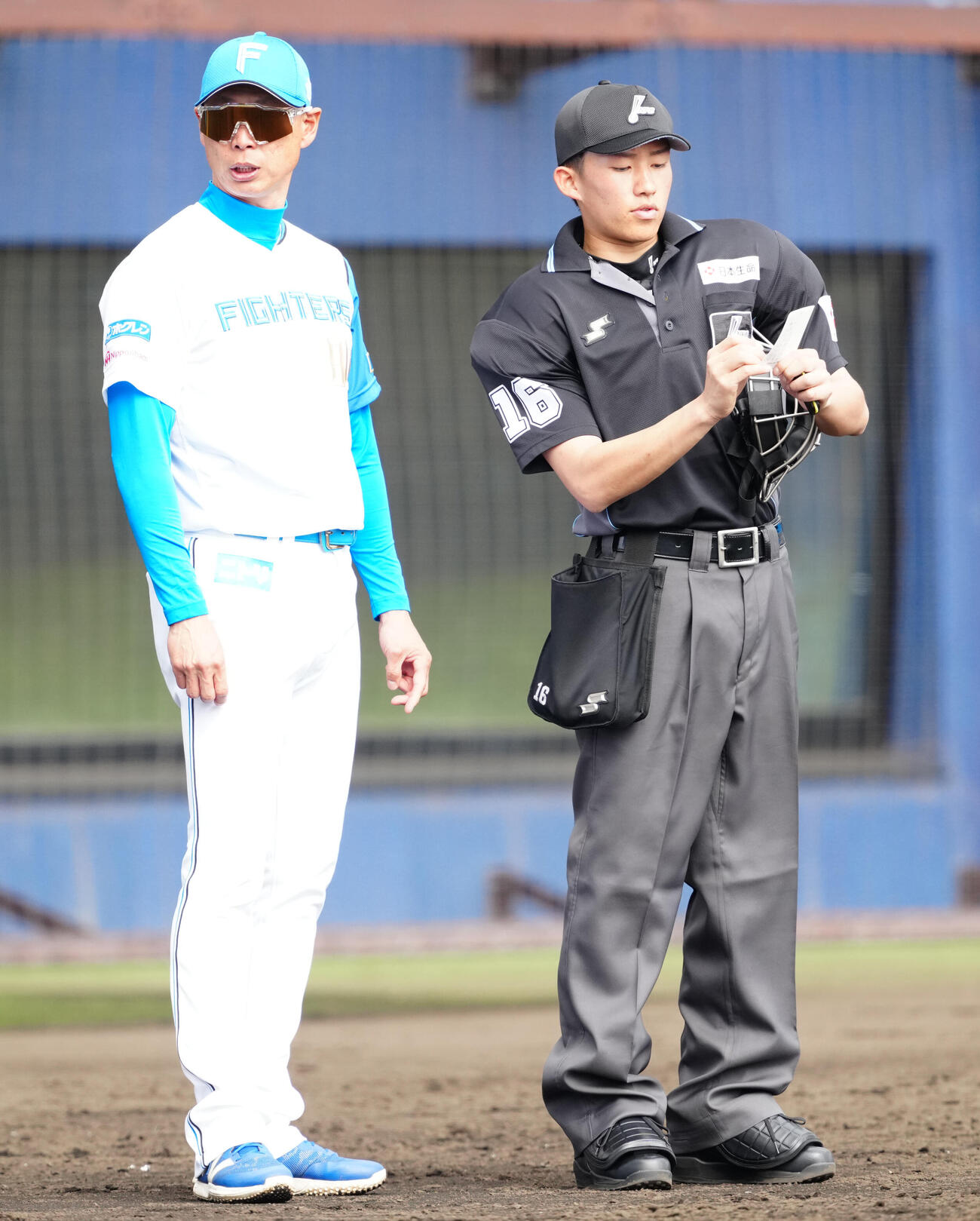 日本ハム対中日　選手交代を告げる日本ハム森本外野守備走塁コーチ（左）（撮影・江口和貴）