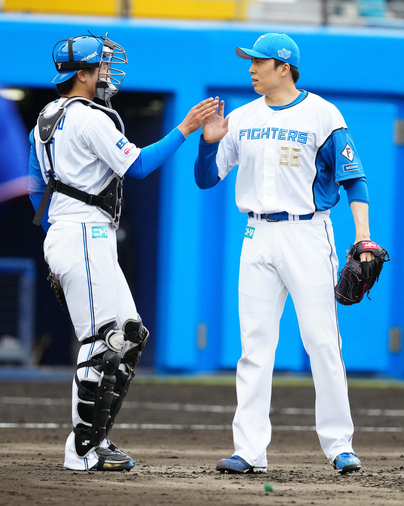 日本ハム対中日　最後を締め、日本ハム捕手清水優（左）とタッチを交わす6番手の田中（撮影・江口和貴）