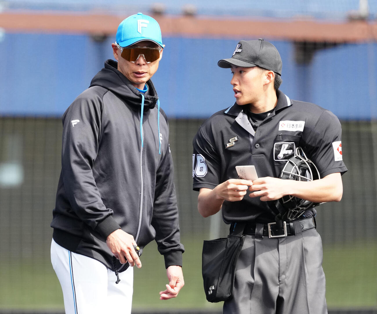 日本ハム対中日　選手交代を告げる日本ハム森本外野守備走塁コーチ（左）（撮影・江口和貴）
