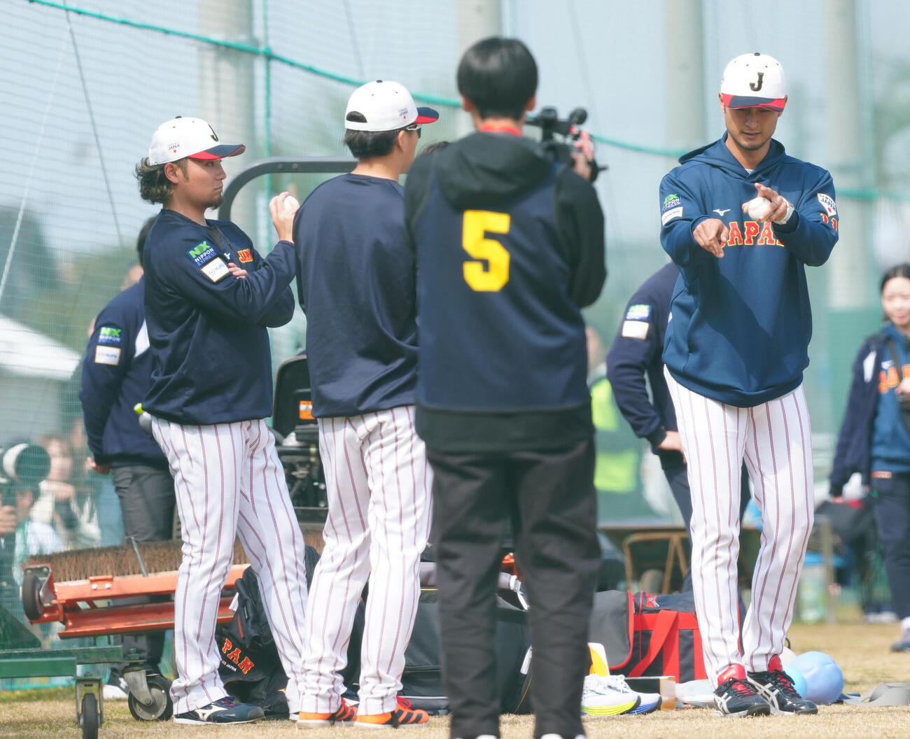 ブルペンを終えた伊藤（左）らと身振り手振りを交え言葉を交わすアドバイザーのダルビッシュ（撮影・垰建太）