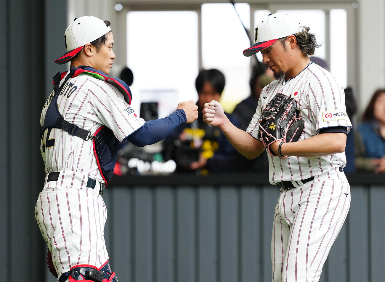 ブルペン投球を終えグータッチを交わす伊藤（右）と坂本（撮影・垰建太）