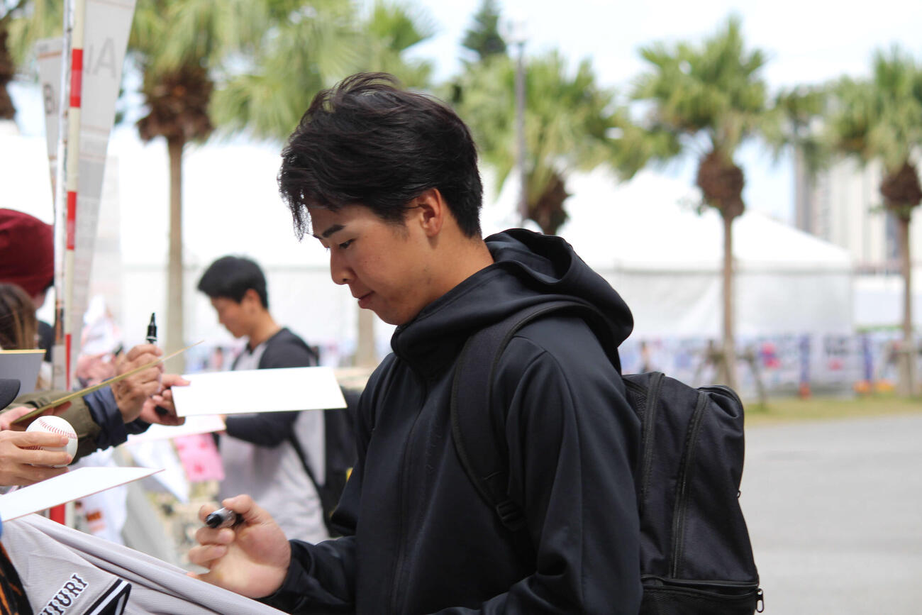休養日返上の練習を終えてファンにサインする小浜