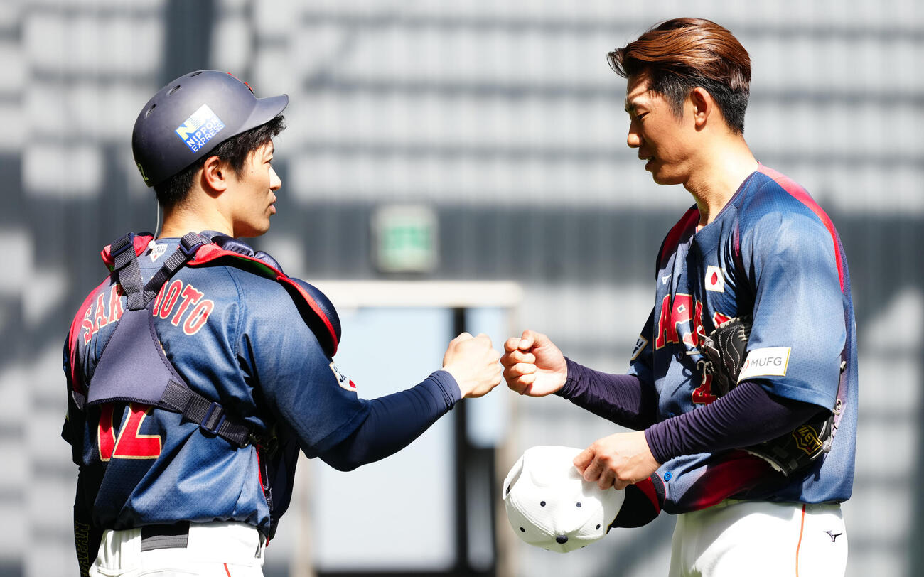 ブルペンをグータッチを交わす曽谷（右）と坂本（撮影・垰建太）