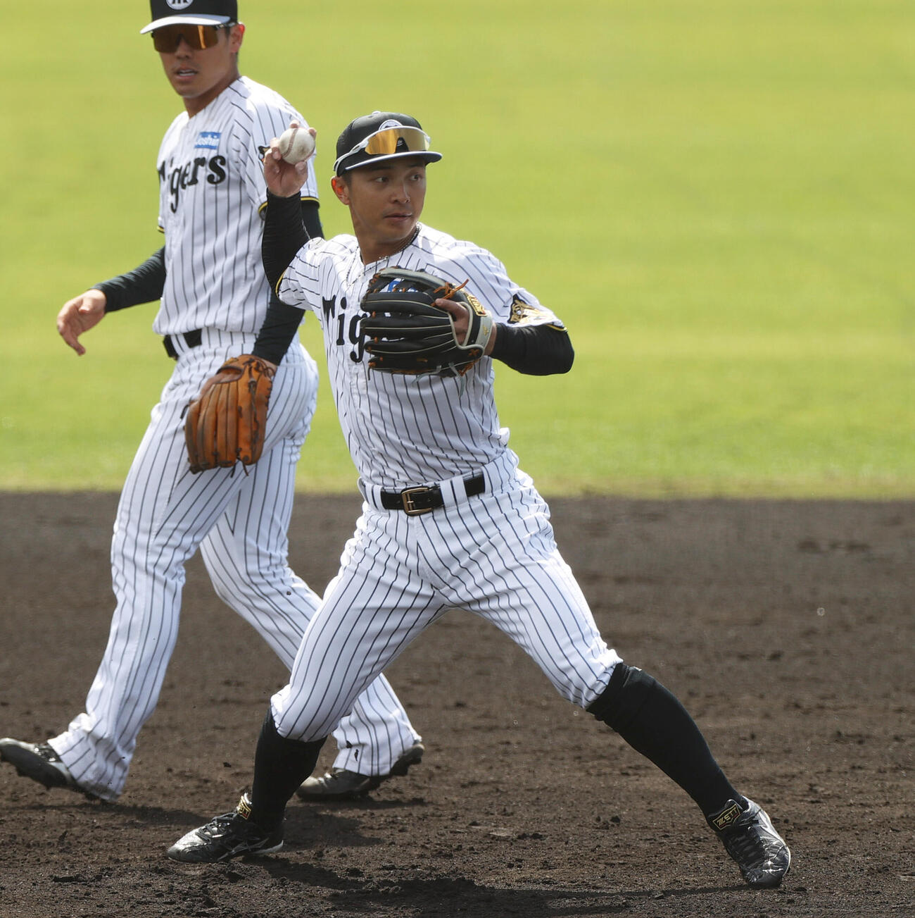 シートノックで遊撃を守る阪神熊谷（手前）（撮影・上山淳一）