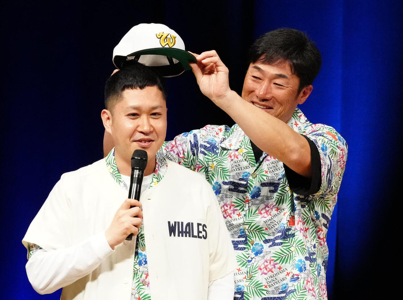 沖縄で開催されるDeNA球団イベントで、お笑いコンビ「ドンデコルテ」の渡辺銀次（左）に大洋ホエールズの帽子をかぶせる相川監督（撮影・江口和貴）