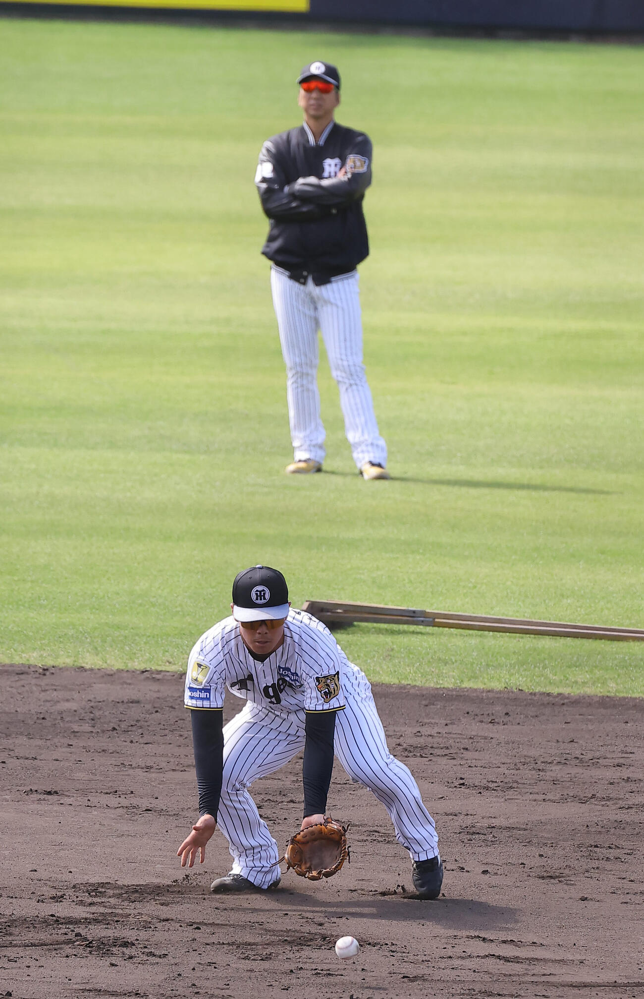 藤川監督のチェックを受けながら二塁ノックを受ける谷端（撮影・上田博志）