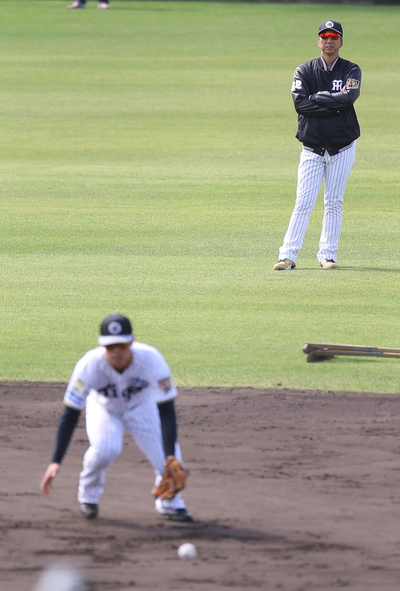 二塁ノックを受ける谷端を見守る藤川監督（撮影・上田博志）