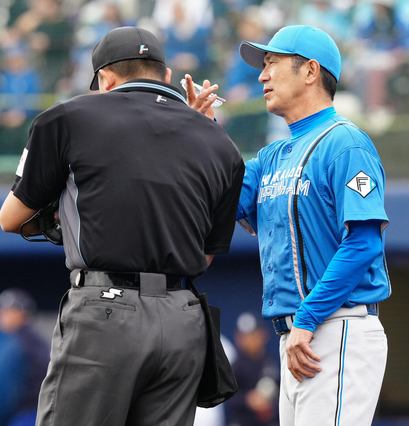 中日対日本ハム　選手交代を告げる日本ハム山田バッテリーコーチ（右）（撮影・江口和貴）