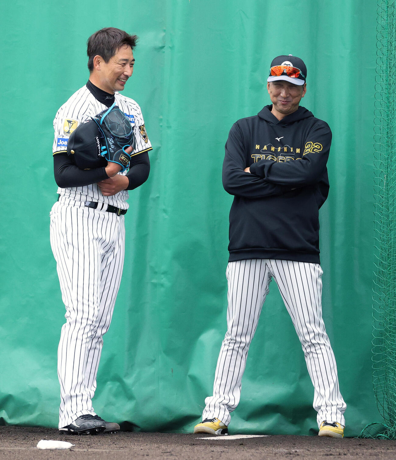 ブルペンで投球を終えた阪神岩崎（左）は藤川監督と笑顔で話す（撮影・上山淳一）
