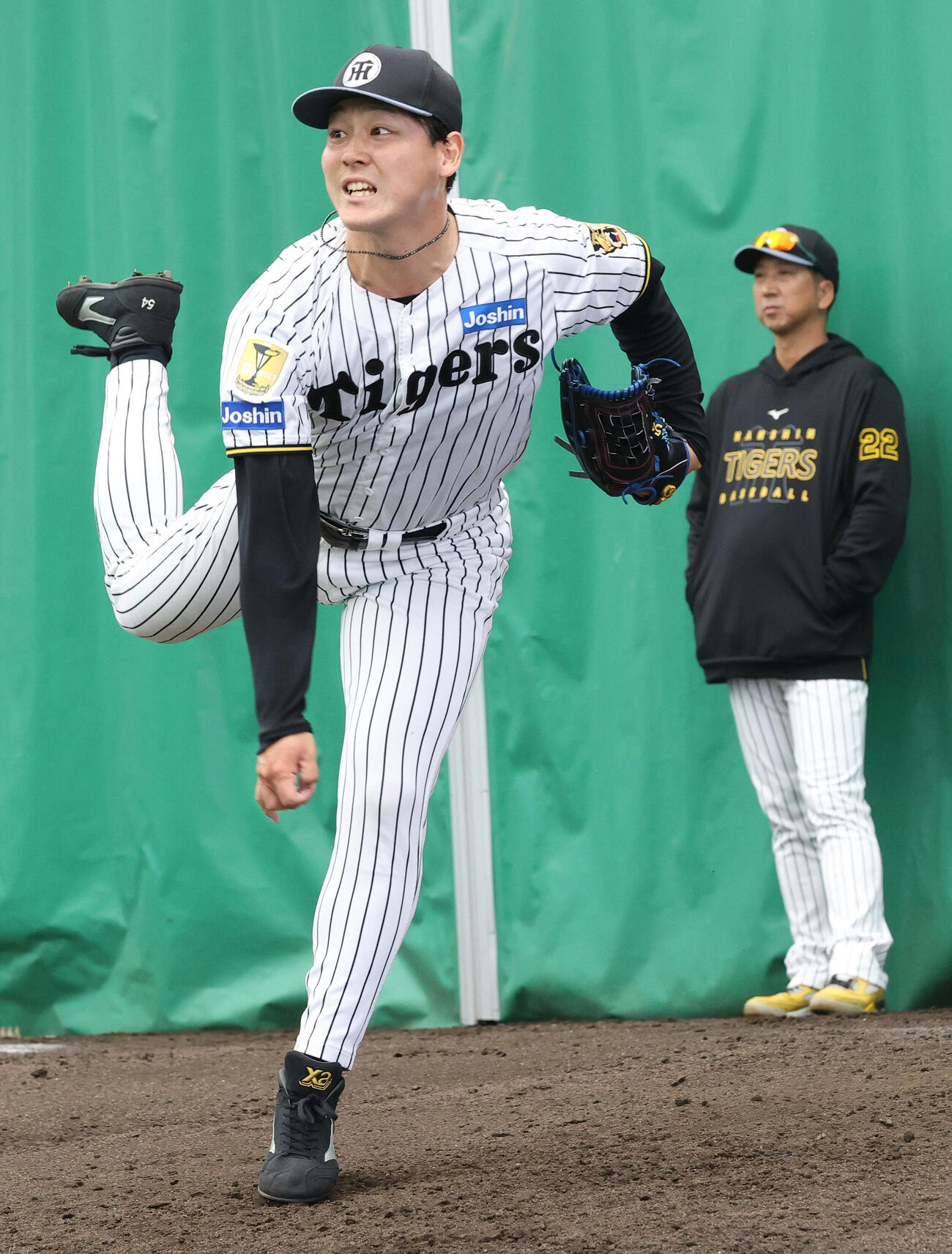 ブルペンで阪神藤川監督（左）が見守る中、投球する木下（撮影・上山淳一）