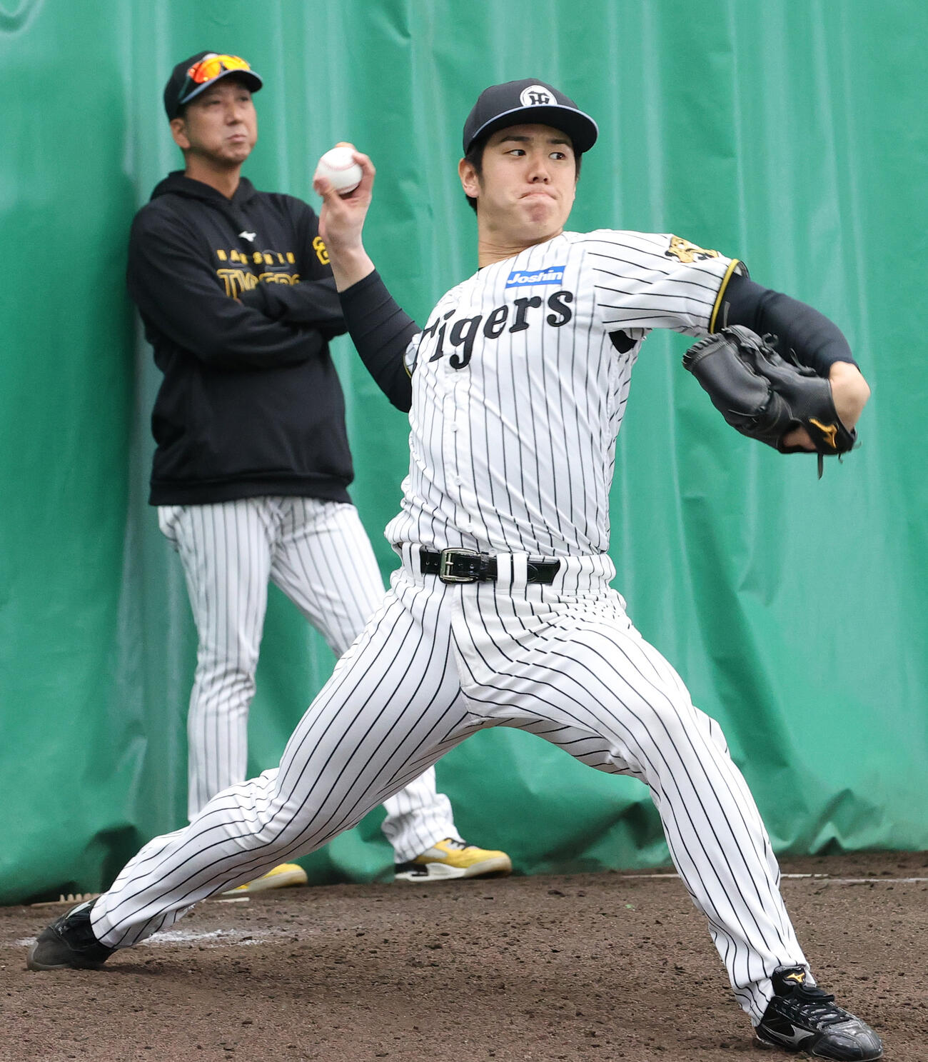 ブルペンで阪神藤川監督（左）が見守る中、投球する石黒（撮影・上山淳一）