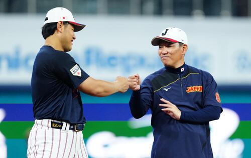 練習中に話しグータッチを交わす岡本（左）と井端監督（撮影・垰建太）