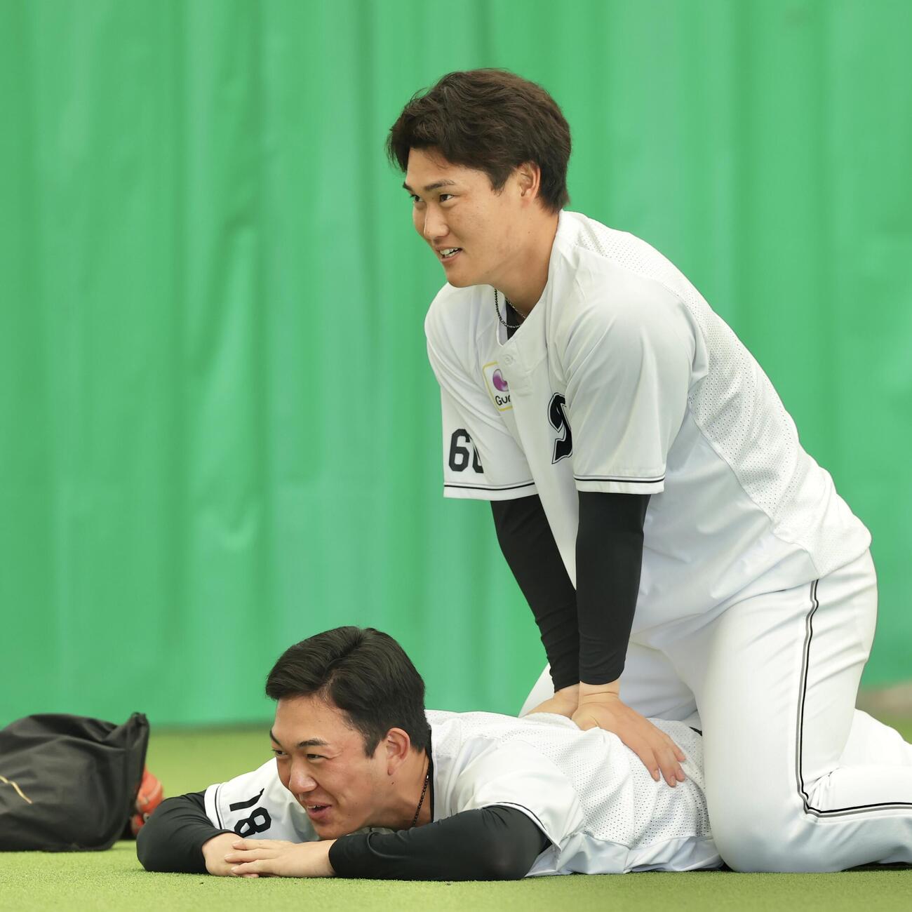 ストレッチするロッテ石垣（下）と大聖（撮影・河田真司）
