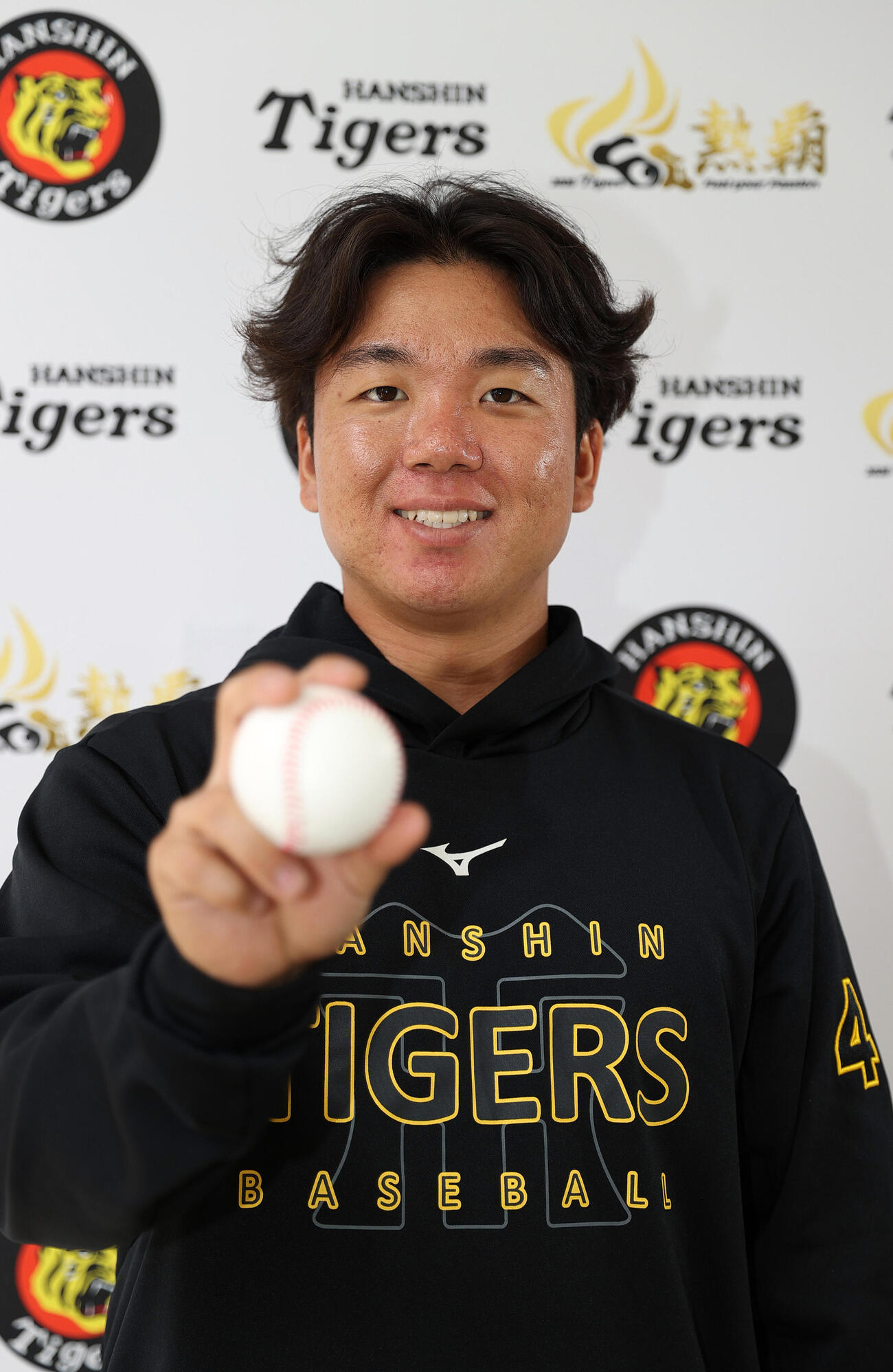 宜野座でインタビューした阪神村上はボールを手に笑顔を見せる（撮影・上山淳一）