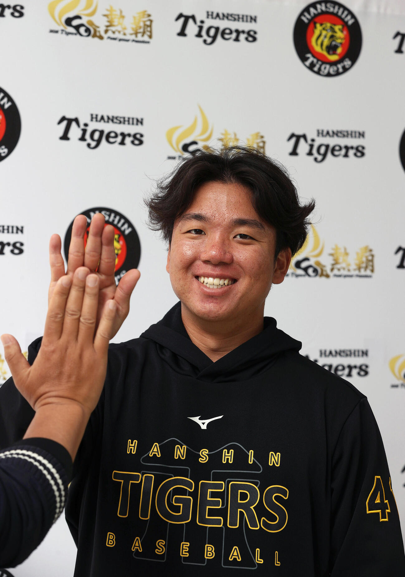 阪神村上は宜野座でインタビューを終え、笑顔でハイタッチする（撮影・上山淳一）