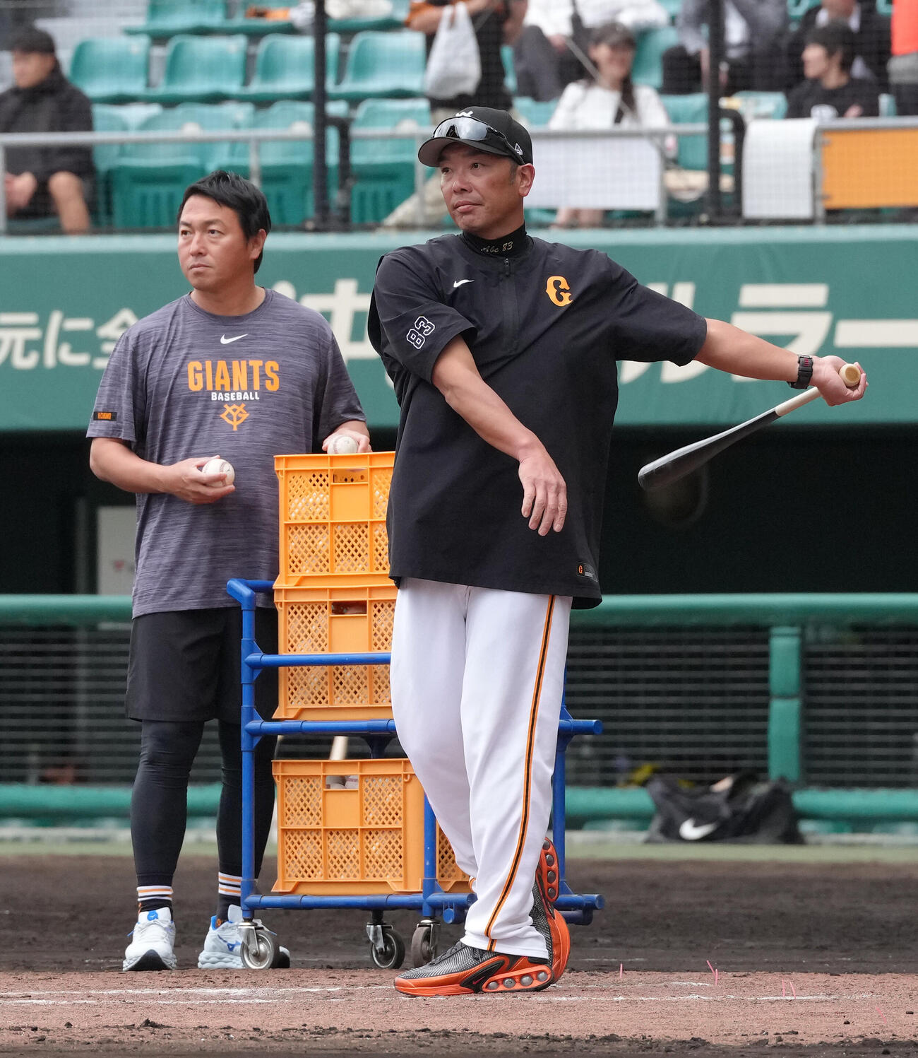 全体練習後、ノックを行う巨人阿部監督（右）。左は長野編成本部参与（撮影・足立雅史）