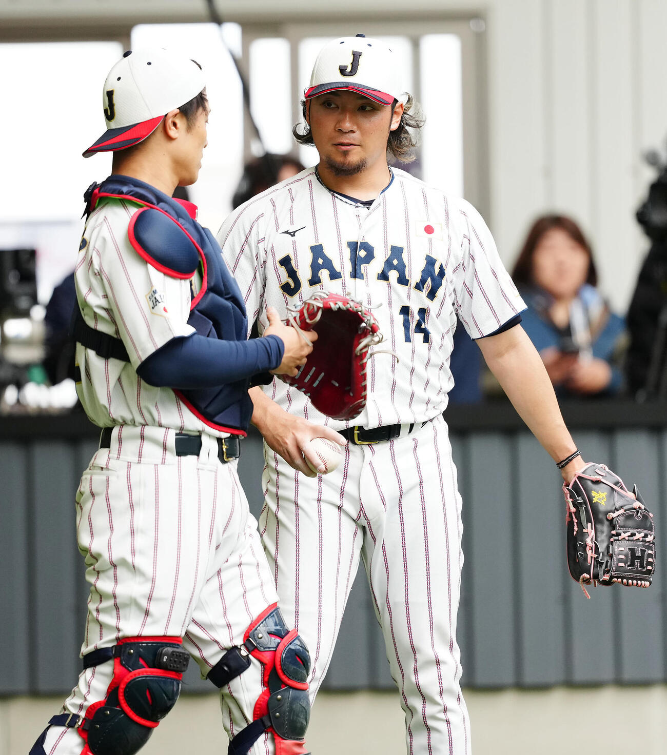 ブルペン投球を終え言葉を交わす伊藤（右）と坂本（2026年2月15日撮影）